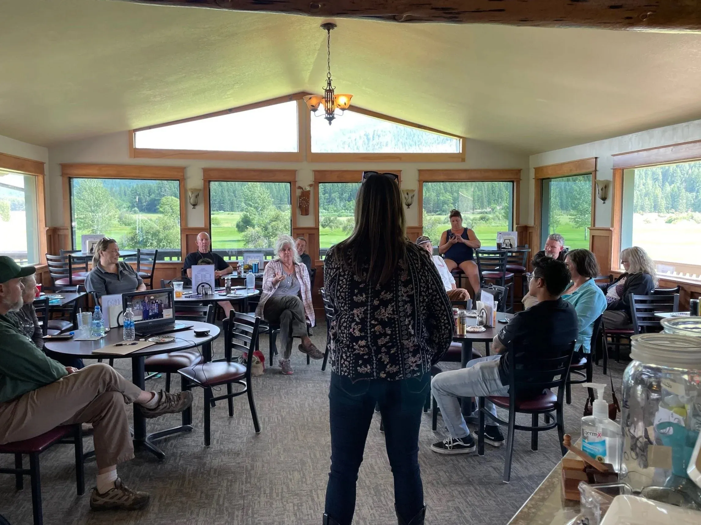 An IVIH business workshop, with a presenter speaking to attendees seated at tables
